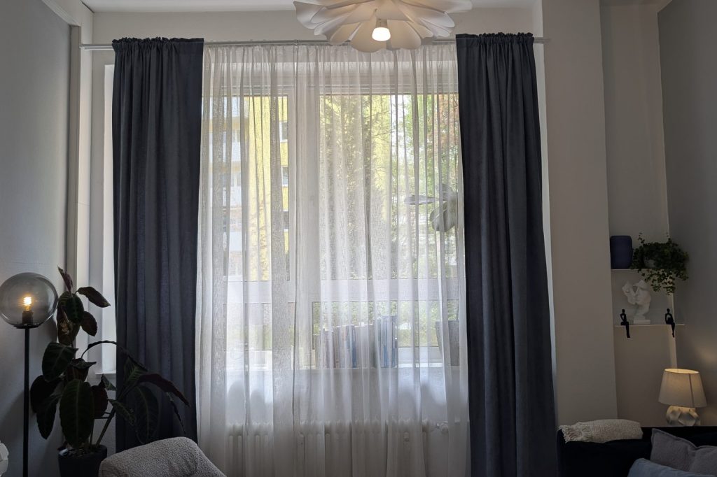 Fenster des Therapieraums mit halb zugezogenen Vorhängen und weichem Licht