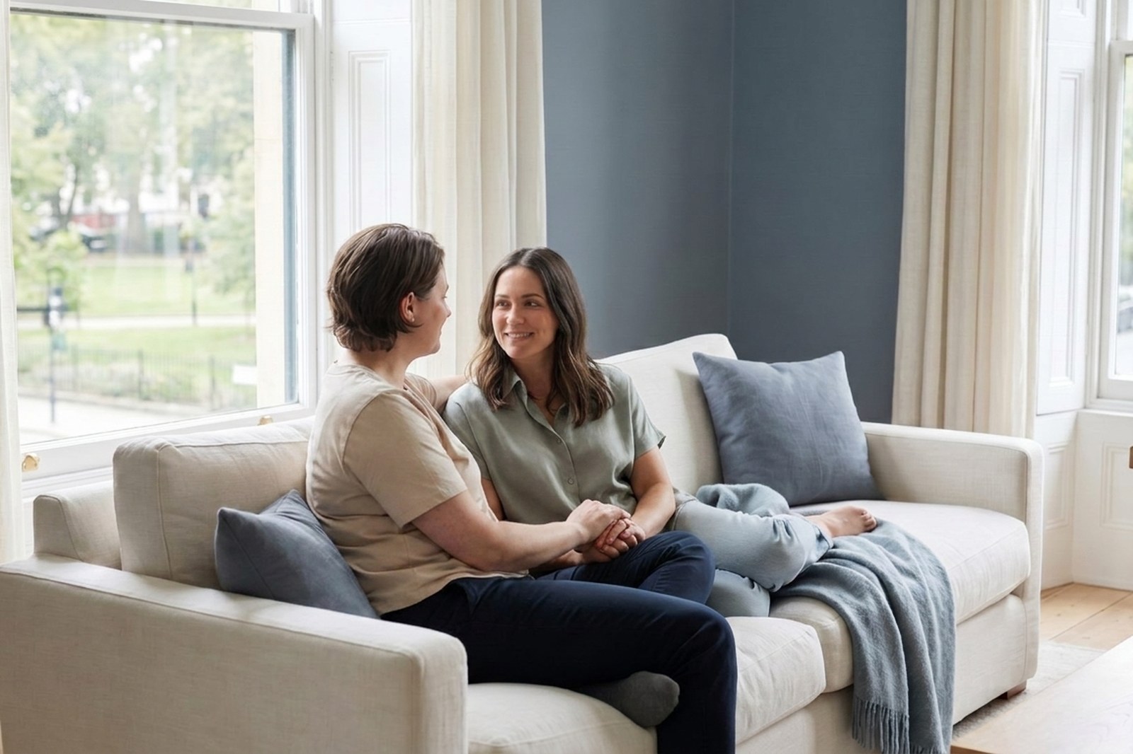 Zwei Frauen sitzen nebeneinander auf dem Sofa und sprechen miteinander